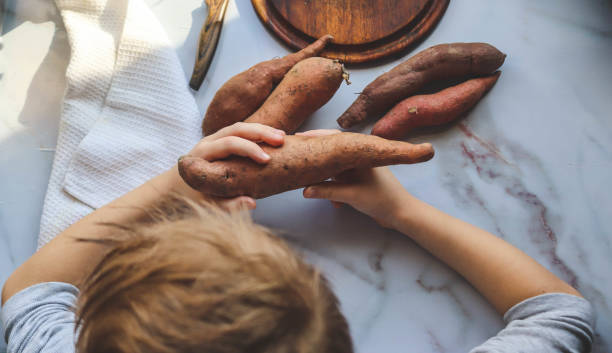 istock boy cooking sweet potato himself in the kitchen 2200010488