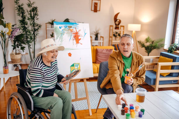 Spending time with older woman with disability creating image on art canvas