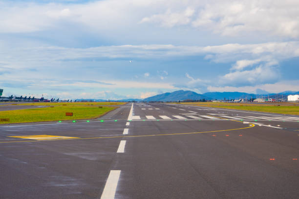 istock Runway stretches toward distant mountains under a cloudy sky at an airport 2200013169