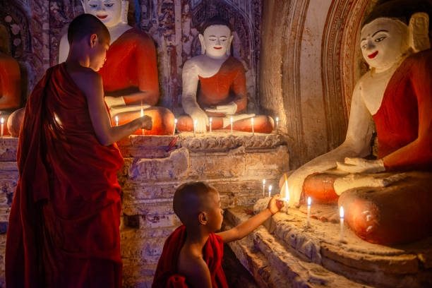 istock Young buddhist monks lighting candles at bagan temple in myanmar 2200013189