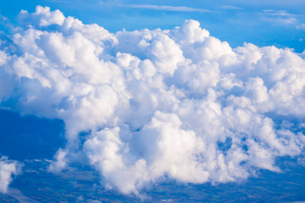 Lush white clouds stretch across a serene blue sky, observed from an aerial perspective on a sunny day, inviting daydreams.