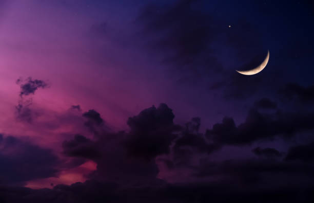 Ramadan Crescent Moon ushering in a Holy Month,Eid Mubarak Background,Night sky dark purple sky,cloudy with Waxing Crescent Moon.Concept for beginning of the month in the lunar Islamic calendar