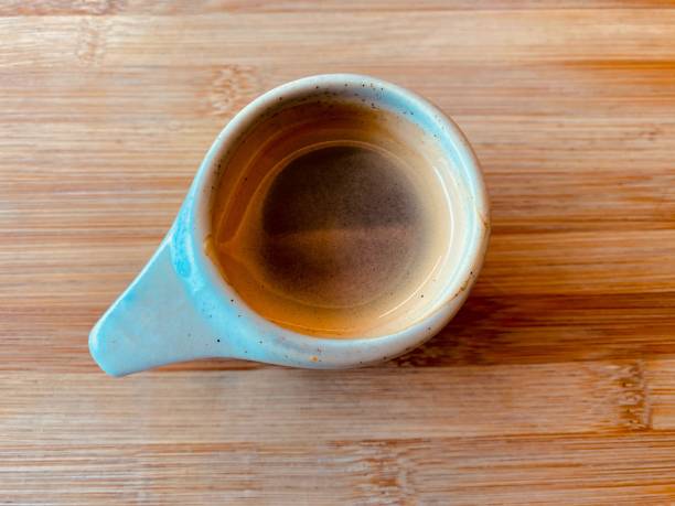 istock Cozy coffee shop scene featuring a coffee cup on a rustic table. Soft natural light highlights the rich textures, creating an inviting and warm ambiance ideal for lifestyle, hospitality, and café-themed projects. Top view 2200016050