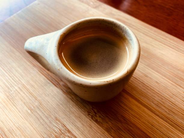 Cozy coffee shop scene featuring a coffee cup on a rustic table. Soft natural light highlights the rich textures, creating an inviting and warm ambiance ideal for lifestyle, hospitality, and café-themed projects. Top view