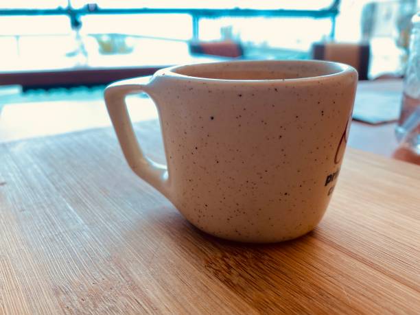 Cozy coffee shop scene featuring a coffee cup on a rustic table. Soft natural light highlights the rich textures, creating an inviting and warm ambiance ideal for lifestyle, hospitality, and café-themed projects