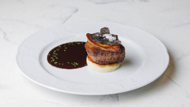 istock Appetizing medallion with foie gras, truffle and sauce on a large white plate 2200016773