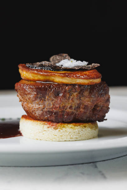 Appetizing medallion with foie gras, truffle and sauce on a large white plate