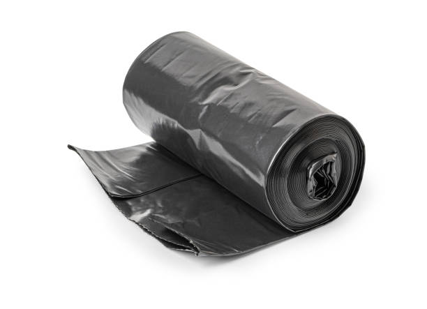 istock Roll of black garbage bags resting on white background 2200017467