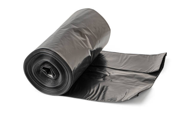 istock Roll of black garbage bags unrolling on white background 2200017473