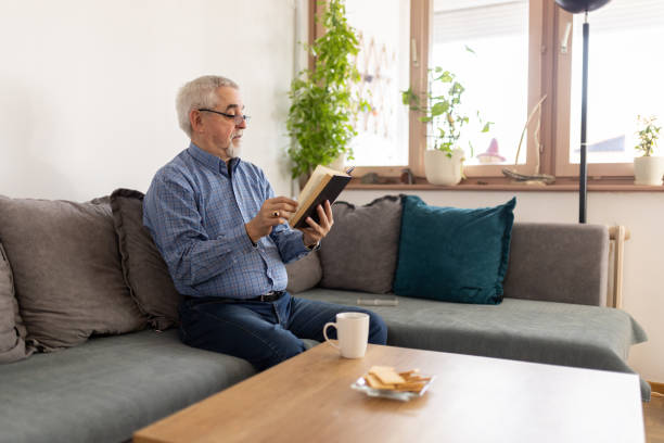 istock Senior man reading a book at home 2200019124