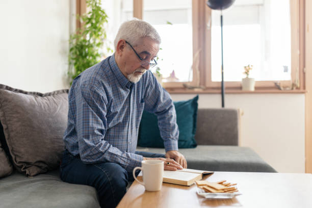 istock Senior man reading a book at home 2200019145