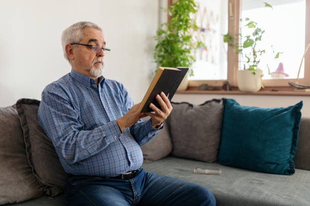 istock Senior man reading a book at home 2200019149