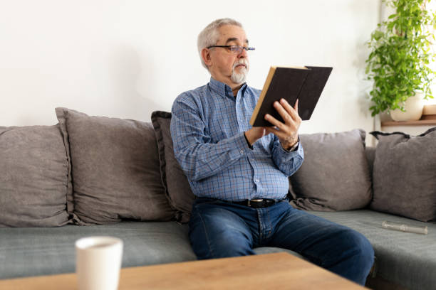istock Senior man reading a book at home 2200019151