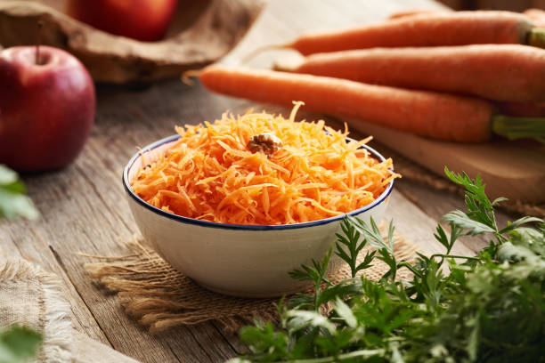 istock Fresh carrot salad on a table with red apples 2200019309