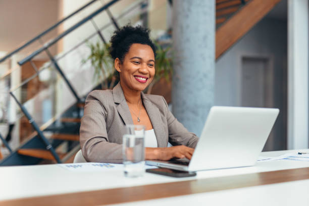 istock Smiling businesswoman working on laptop in modern office 2200020721