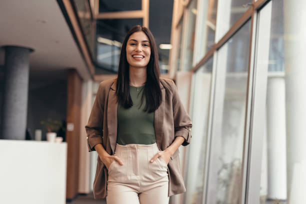 Confident businesswoman walking through modern office building