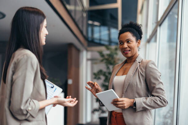 istock Two businesswomen discussing using digital tablet and clipboard in modern office 2200020803