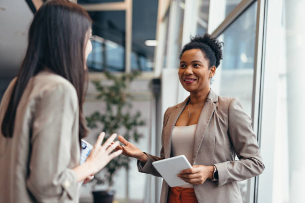 istock Two businesswomen discussing work in modern office building 2200020812