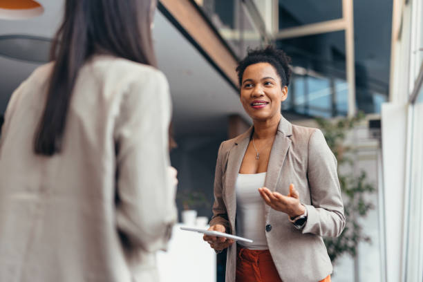 istock Two businesswomen having a conversation in modern office building 2200020840