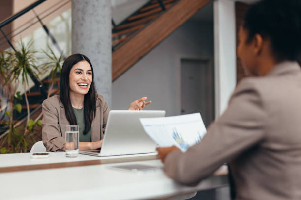 istock Businesswomen discussing graphs using laptop in modern office 2200020882