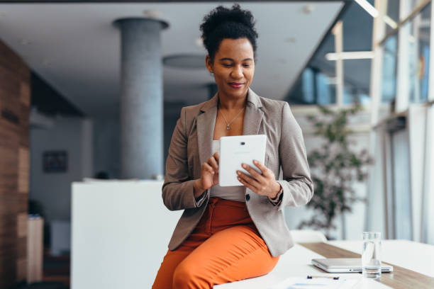 istock Businesswoman using digital tablet sitting on desk in modern office 2200021009