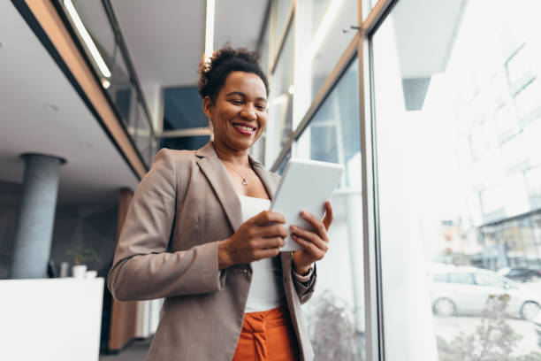 istock Smiling businesswoman using digital tablet in modern office building 2200021050
