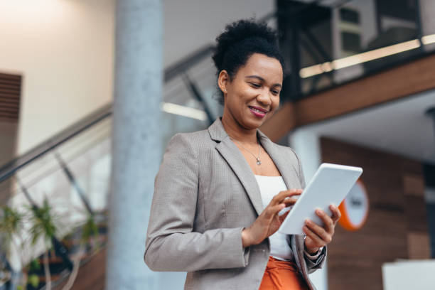 istock Smiling businesswoman using digital tablet in modern office building 2200021797