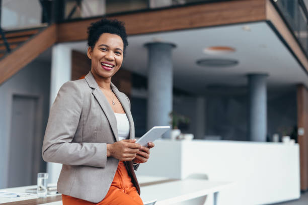 istock Smiling businesswoman holding tablet in modern office 2200021809