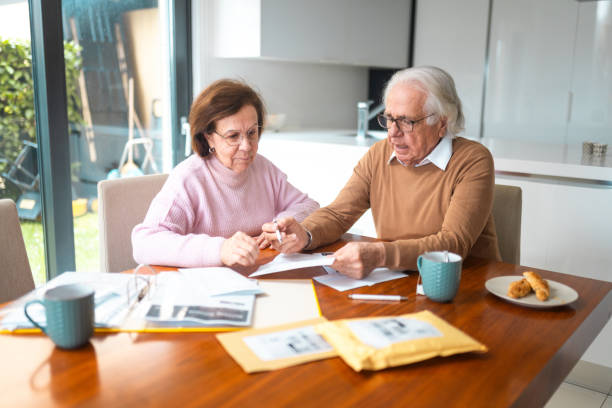 istock Older Hispanic Couple Sorting Bills and Financial Documents at Home 2200023000