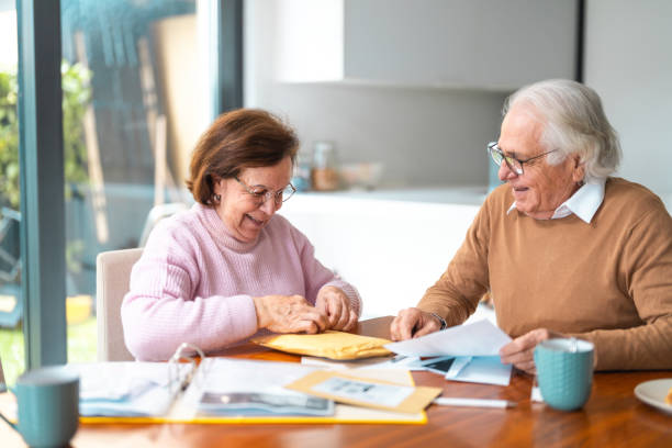 istock Elderly Hispanic Couple Enjoying Mail in Cozy Dining Room 2200023008