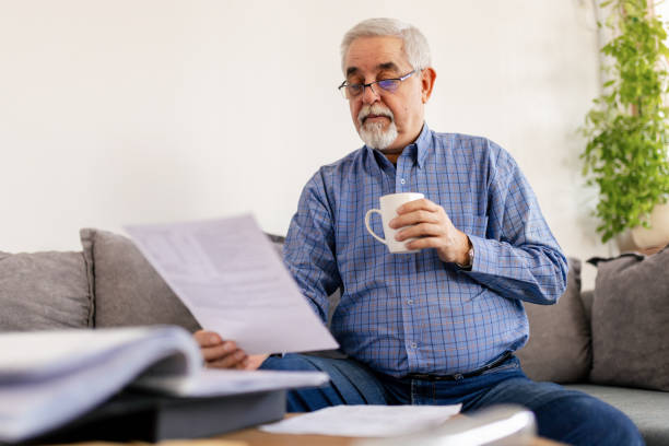 istock Senior man holding bills and planning home budget 2200028738