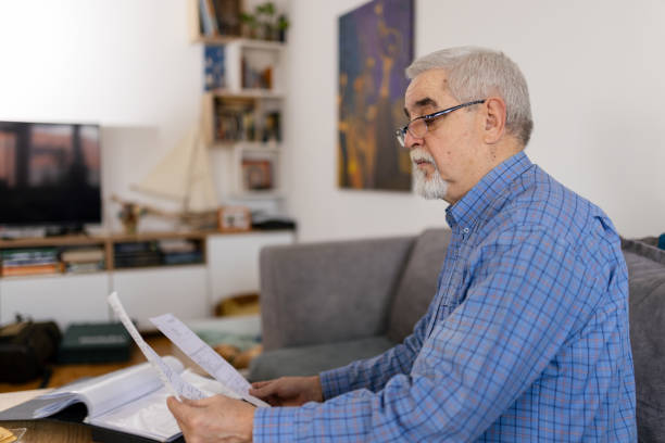 istock Senior man holding bills and planning home budget 2200028748