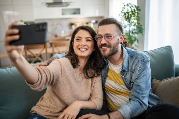 istock Cheerful young couple taking a selfie together on a sofa 2200029519