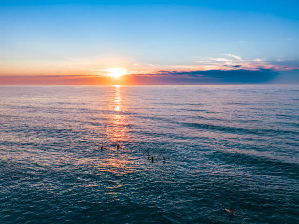 A drone view of the sun rising over the horizon as it reflects on the ocean. The location is Wrightsville North Carolina.