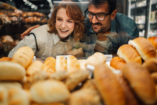 istock Happy couple choosing bread in supermarket bakery display 2200032249