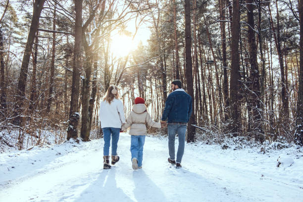 istock Family having a walk in a winter forest while holding hands 2200038870