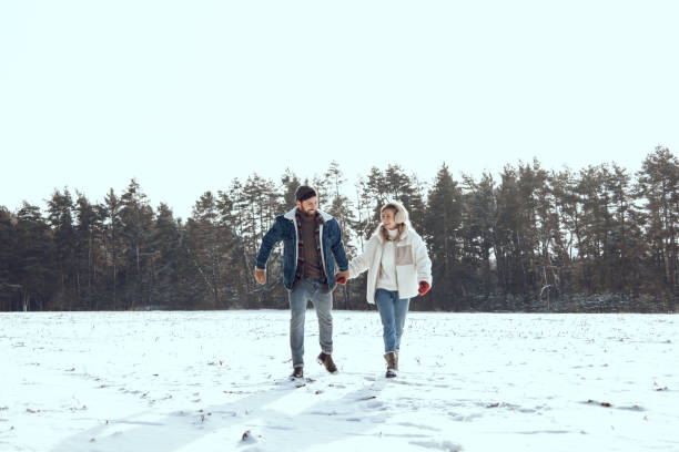 istock Two people spending a day in a winter forest and looking enjoyed and romantic 2200038965