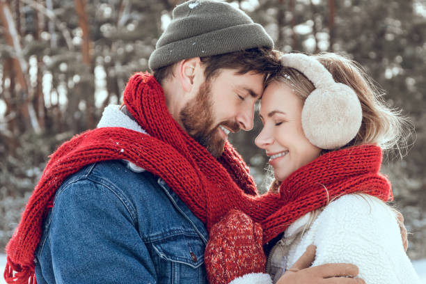 istock Man and woman looking romantic while having a walk in a winter forest 2200039012