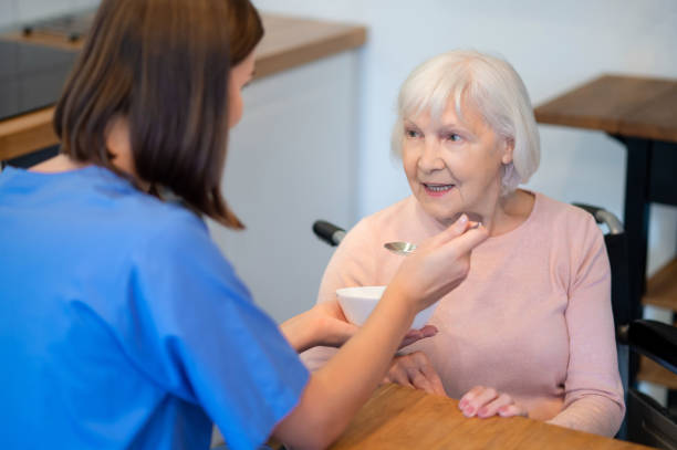 istock Nurse feeding elderly patient soup at home during sickness 2200042558