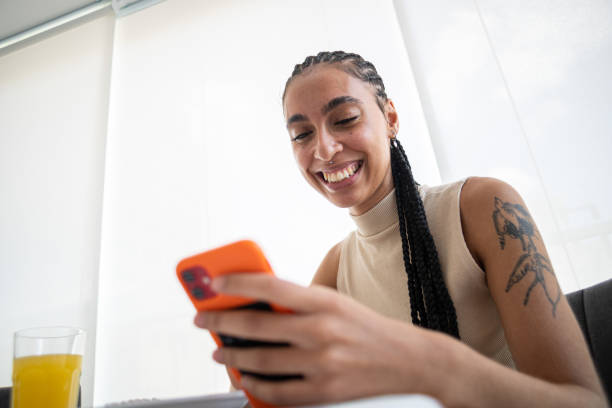 istock Smiling young woman using her smartphone 2200044007