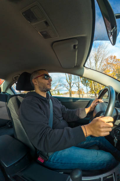 istock A man is driving a car with his hands on the steering wheel 2200046847