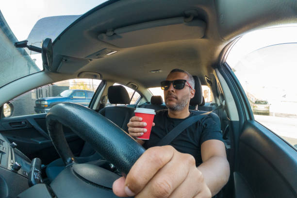 istock A man is driving a car with a red cup in his hand 2200046864