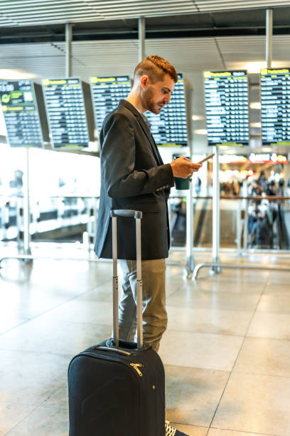 istock Businessman using smartphone while waiting at the airport 2200048534