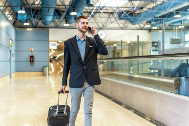 istock Businessman walking through airport terminal while talking on phone 2200048635