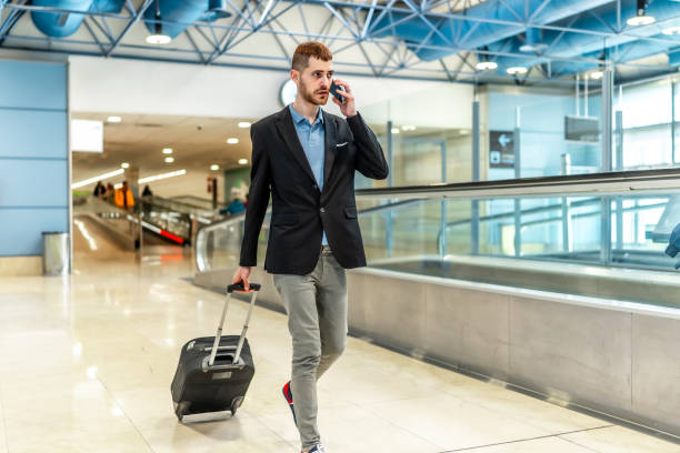 istock Businessman walking through airport while talking on phone 2200048804