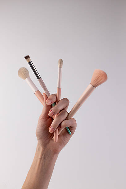 istock A Handful of Four Diverse Makeup Brushes Displayed Elegantly Against a Simple Blank Background, Highlighting Their Unique Shapes and Textures Perfect for Various Beauty Applications. 2200048810