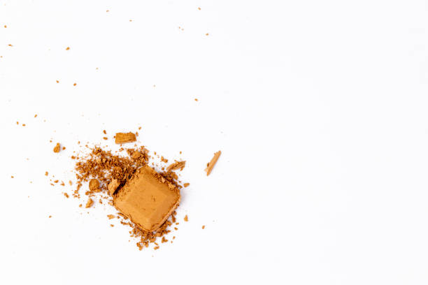 istock Close-Up of Crumbled Brown Powder with Rectangular Piece on Simple White Background Highlighting Textural Details and Color Variation 2200050794