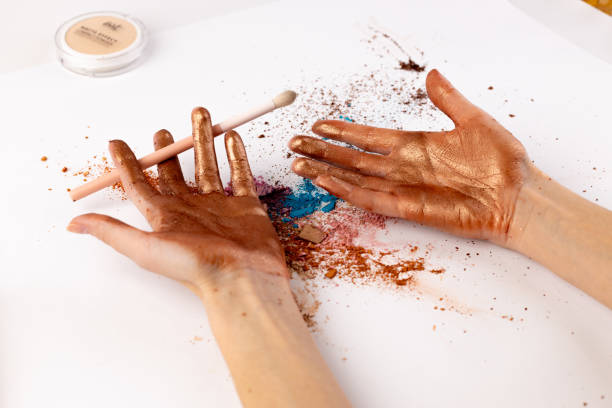 istock Creative Hands Covered in Colorful Makeup Powders with a Makeup Brush Amidst a Messy Artistic Setup for Beauty and Art Lovers to Explore Unique Aesthetics 2200052472