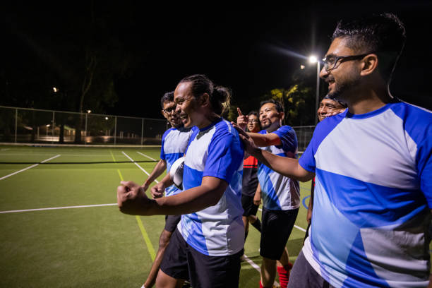 Soccer players walk off the pitch after a challenging and intense match, displaying a sense of relief and accomplishment.