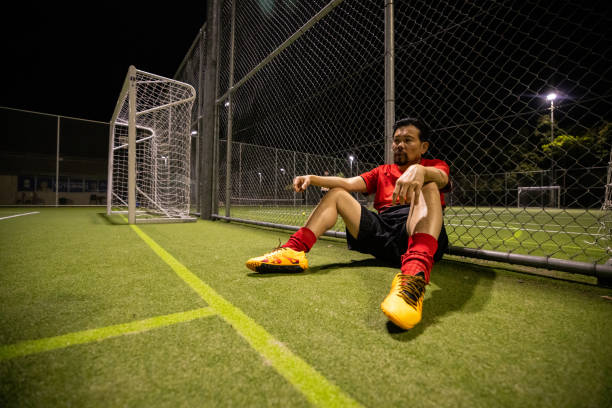 Takes a break. Young soccer player have training on the sportive field.